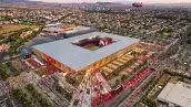 Render aéreo del nuevo estadio del Atlas en Zapopan, con cancha de futbol, tribunas llenas, explanadas exteriores y zonas urbanas alrededor.
