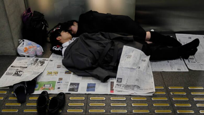 Varias personas duermen en el Tokio International Forum, un centro de espectáculos adaptado como un refugio temporal.