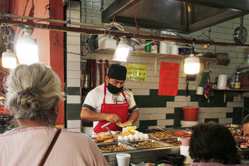 ESTE VIERNES LOS COMERCIANTES DEL MERCADO SAN ANGEL SE PROTEGEN DEL COVID-19 CON TAPABOCAS MIENTRAS COCINAN ANTOJITOS MEXICANOS SIN GUANTES PARA EL DESAYUNO DE ESTE VIERNES 20 DE MARZO EN LA CIUDAD DE MÉXICO.