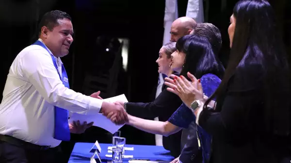 graduado recibiendo su diploma en la graduación de 2023 de la Universidad Corporativa Coppel. 