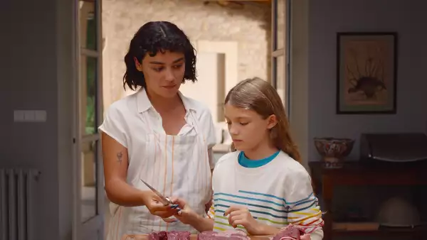 Foto de una escena de la película 'Delicia' de Netflix con Teodora dándole de comer carne cruda a la pequeña Alba. (Imagen principal del artículo "‘Delicia’: su reparto y de qué trata la película alemana de Netflix de la que todos hablan").