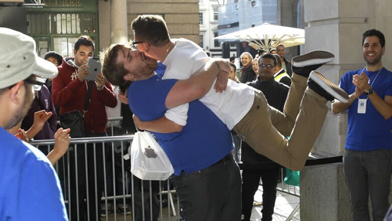 Un comprador salta a los brazos de un empleado de la tienda de Apple en Londres, tras comprar el iPhone 4S.