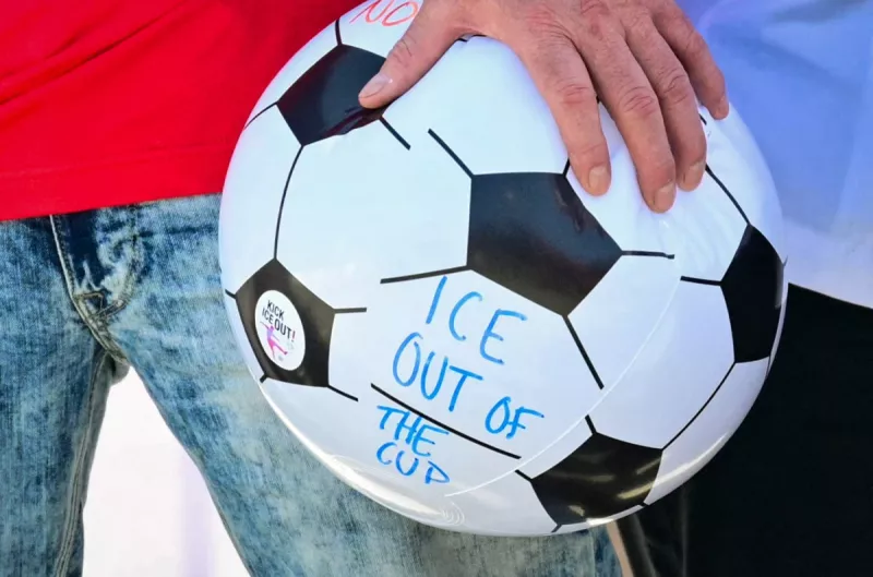 Un hombre sostiene una pelota con el mensaje "ICE fuera de la copa" mientras está de pie con los trabajadores del estadio SoFi representados por Unite Here 11 durante una conferencia de prensa sobre una actualización de las negociaciones de contrato en el estadio SoFi en Inglewood, California, el 9 de junio de 2026.