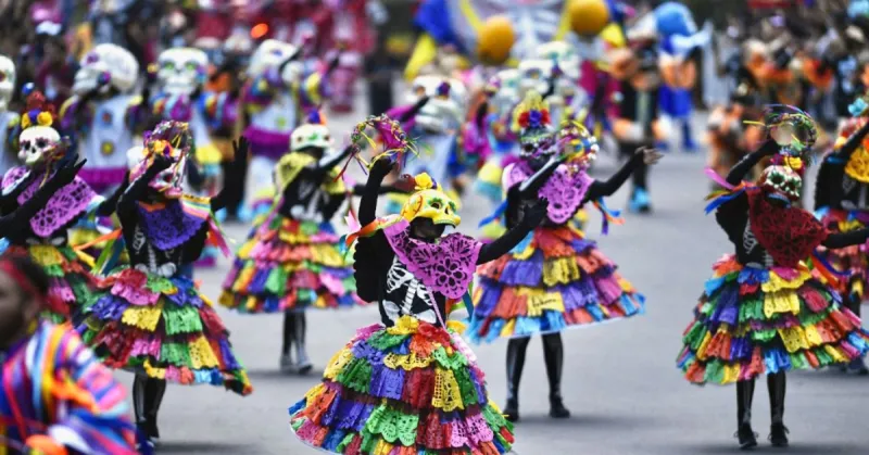 Personas con papel picado como vestidos y máscaras de calavera.jpg