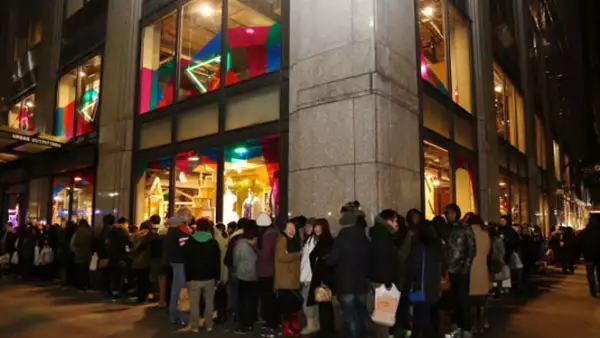 En Nueva York, una fila de asistentes esperan que se abran las puertas luego del 70% de descuento anunciado en la tienda.
