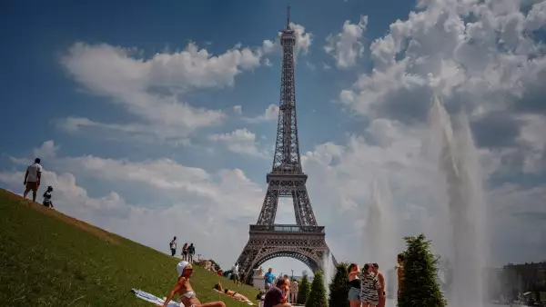 La gente se enfría cerca de la Fuente del Trocadero con la Torre Eiffel de fondo durante una ola de calor en París el 26 de junio de 2026.