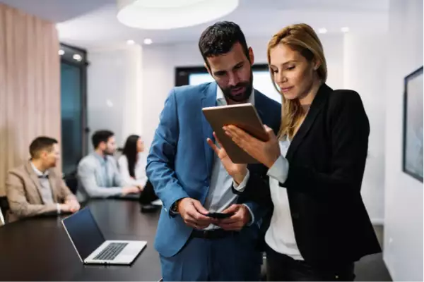 Mujer y hombre trabajando en una tablet.