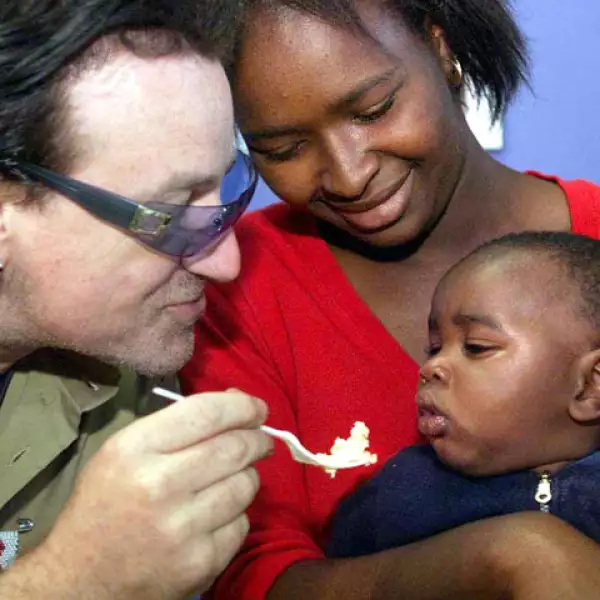 Bono se caracteriza también por ser un activista social. Aquí en África en 2002 alimentando a un pequeño infectado del VIH.