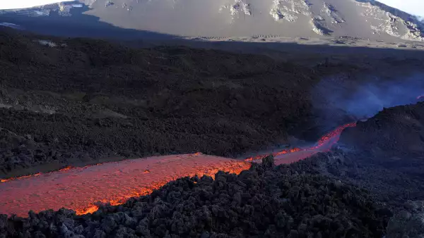 Largos arroyos de lava al rojo vivo fluyen por el cráter sureste del Monte Etna, el volcán más alto y activo de Europa, visto desde Zafferana Etnea, Italia, el 11 de junio de 2022. Foto tomada el 11 de junio de 2022.
