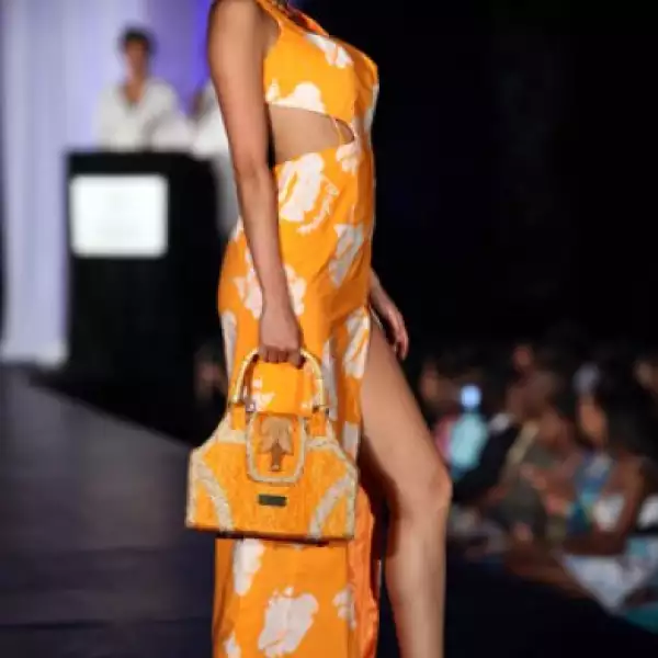 Emiri Miyasaka, de Japón, se veía muy coqueta en este vestido naranja con blanco, además de una pequeña bolsa en el mismo tono. Los zapatos fueron blancos de plataforma que hiciero juego con las flores del atuendo.