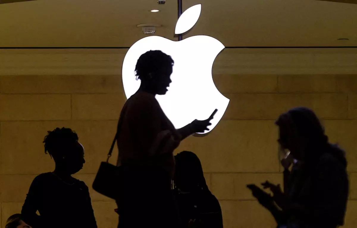 Logo de apple con sombras de personas usando un teléfono