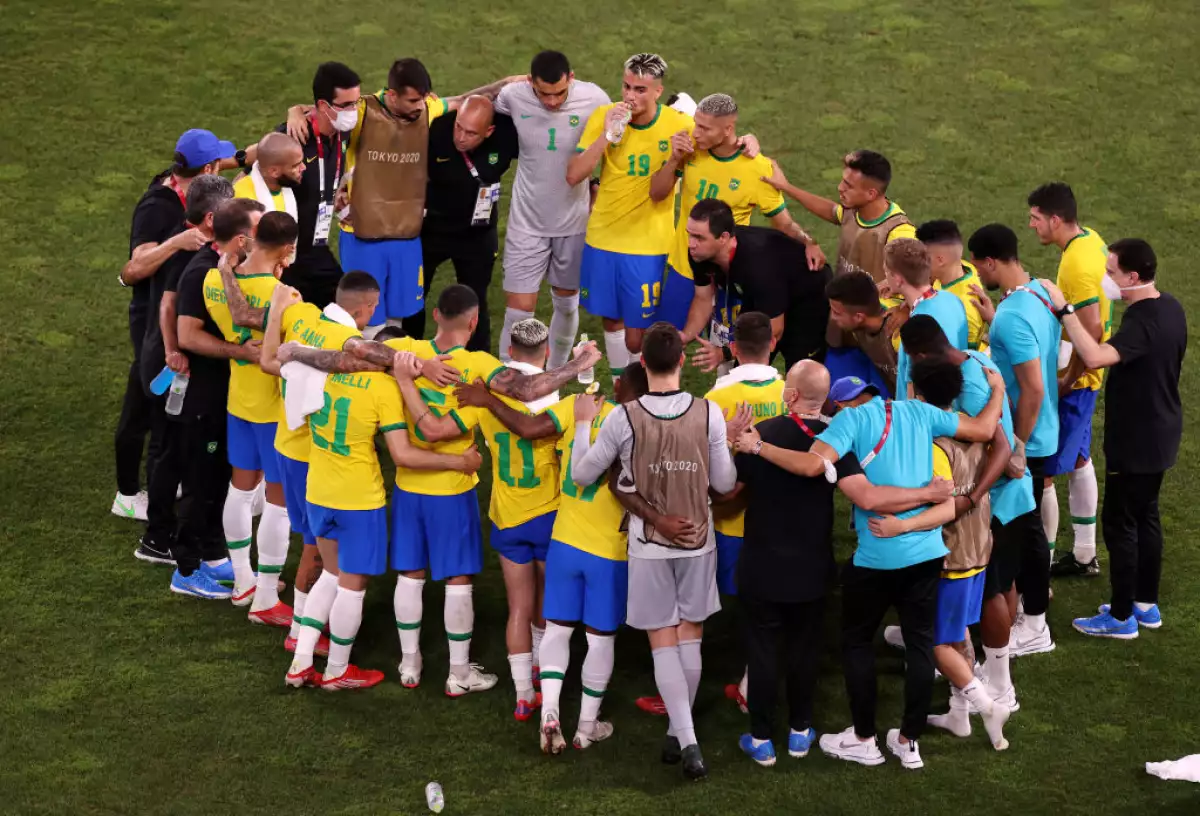 André Jardine en el campo de juego rodeado del equipo de la selección brasileña en los Juegos Olímpicos de Tokio 2020.