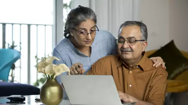 Senior couple using laptop while working on home budget
