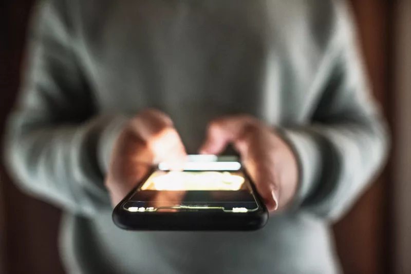 Toma cerrada a un telefono inteligente iluminado en la noche