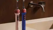 En la foto aparecen dos cepillos dentales Dyson Camerajet sobre la barra de un lavabo.