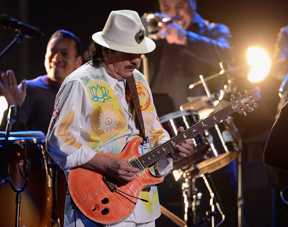 Foto de Carlos Santana en un escenario tocando la guitarra