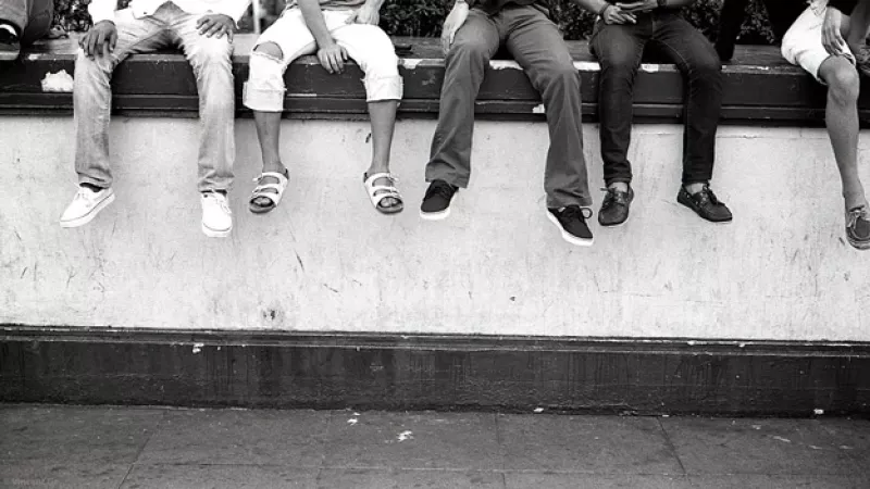 un grupo de adolescenets sentados en una barda