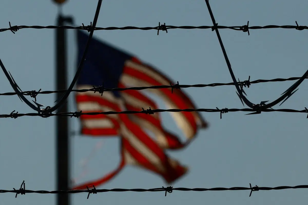 Se ve una bandera de los Estados Unidos cerca del aeropuerto de El Paso mientras los migrantes guatemaltecos, en su mayoría encadenados, son transportados a un avión para ser expulsados de los Estados Unidos a su país de origen por agentes del Servicio de Inmigración y Aduanas de los Estados Unidos (ICE) y agentes de la Patrulla Fronteriza, en el aeropuerto de El Paso, Texas, EE. UU., 13 de junio de 2024.