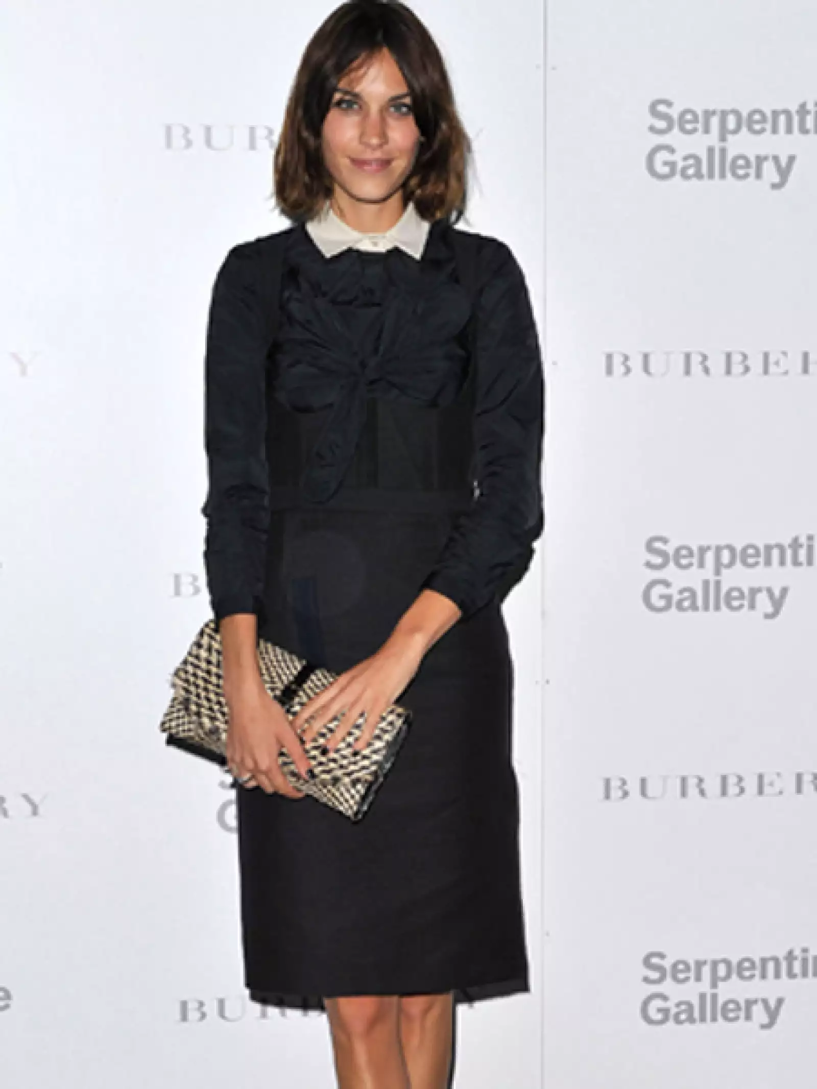 Alexa Chung combina un clutch con un atuendo sobrio.