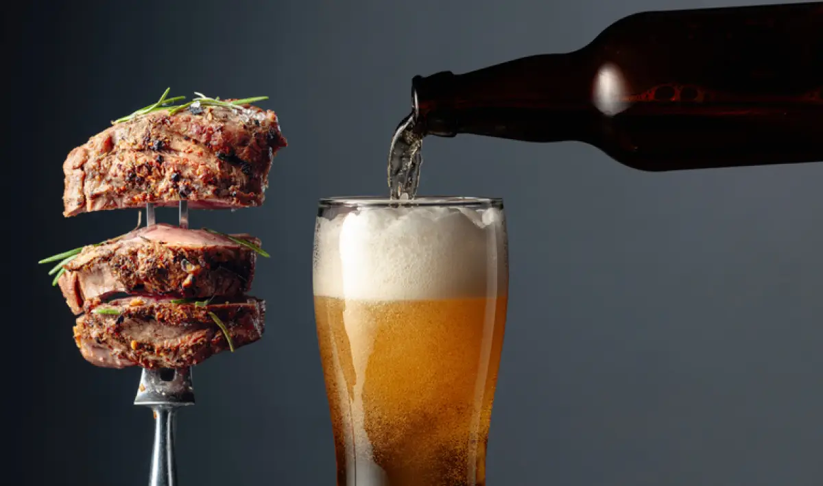 Beer and grilled ribeye beef steak.