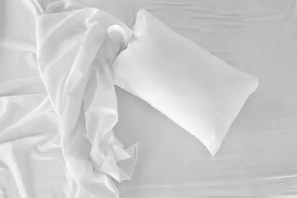 Bird's eye view of a white, unmade bed