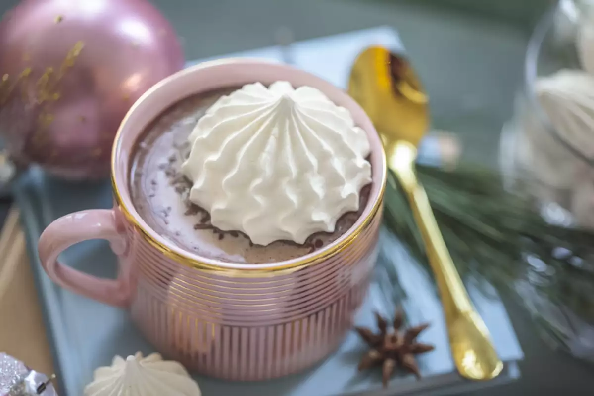 Taza rosa con chocolate rubí caliente y un toque de crema batida.