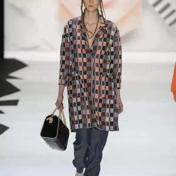 Abrigo geométrico con baggy jeans y sandalias con plataforma.