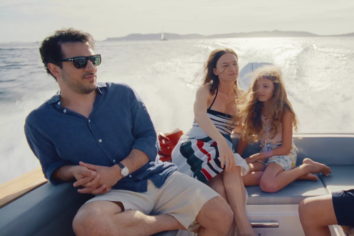Foto de una escena de la película 'Delicia', de Netflix, con Valerie Pachner como Esther, Fahri Yardım como John y Naila Schuberth como Alba paseando por un bote en la riviera francesa.