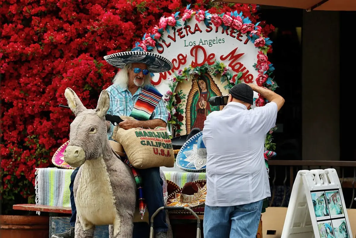 A un visitante se le toma una foto en la calle Olvera, una calle peatonal histórica y un mercado mexicano el 5 de mayo de 2025 en Los Ángeles, California.