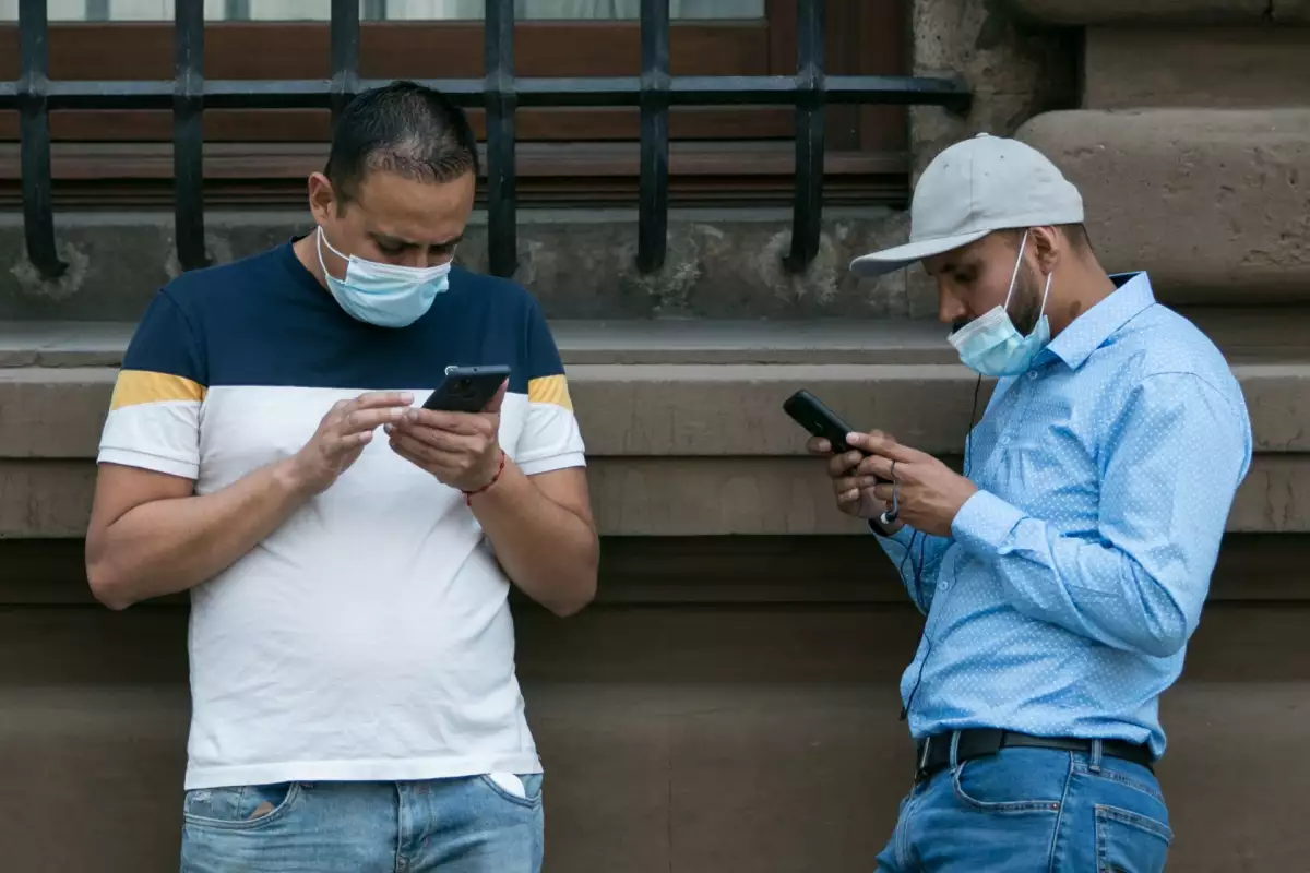 Dos hombres utilizan su teléfono celular en las inmediaciones del Centro Histórico.