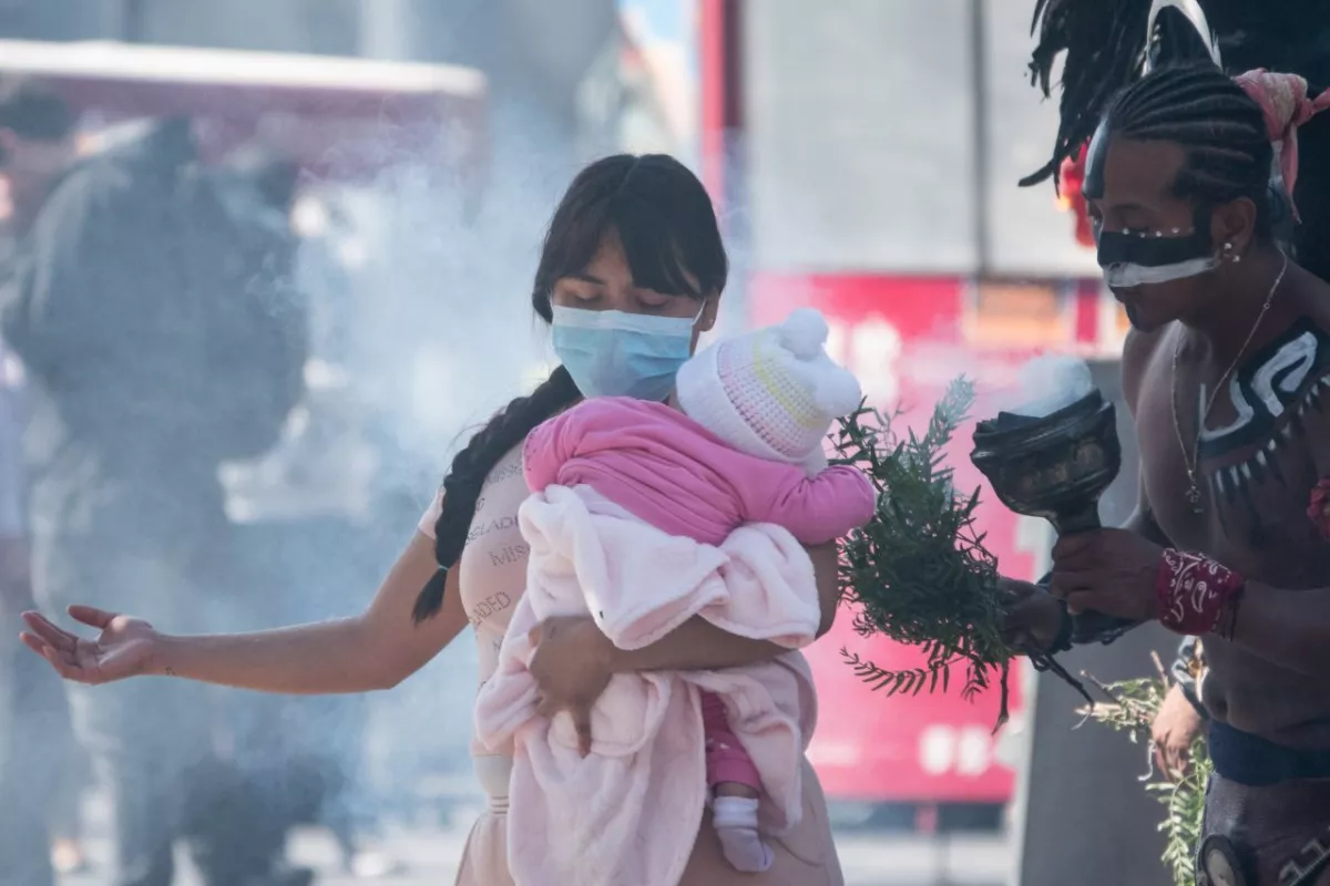 Una mujer y su bebé reciben una limpia de porte de los danzantes que se ubican a un costado de la Catedral Metropolitana.