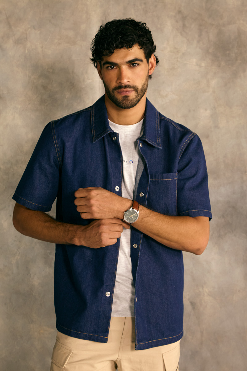 Hombre con camisa denim azul de manga corta y reloj café