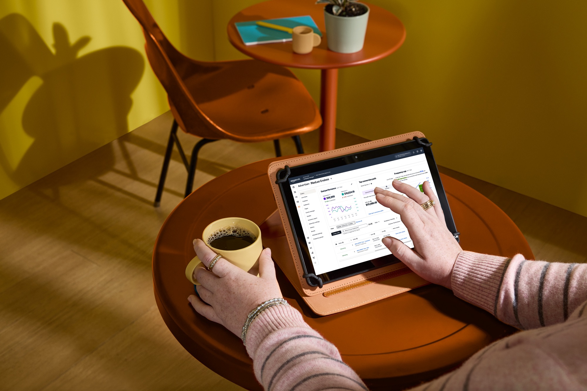 Persona con una taza de café revisando métricas de campaña en una tableta